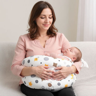 Coussin Allaitement pour Bébé ergonomique à motifs étoiles, utilisé par une maman pour nourrir son enfant en position confortable sur le canapé.