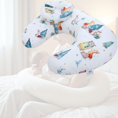 Maman allaitant bébé à l’aide d’un coussin d’allaitement illustré de petits animaux, soulageant les bras et favorisant une posture naturelle pendant la tétée.

