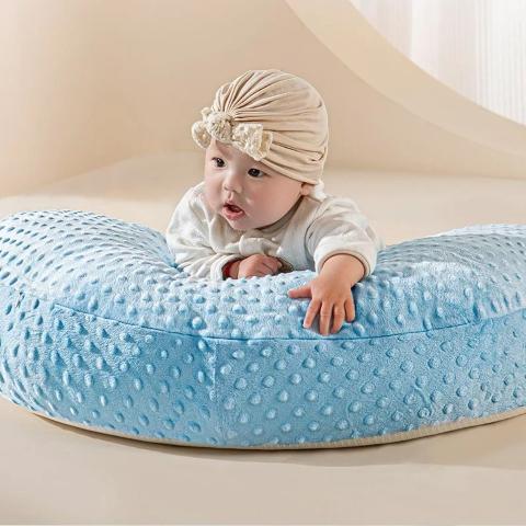 Bébé confortablement installé sur le coussin d’allaitement DreamHaven, la tête légèrement relevée pour faciliter la digestion.