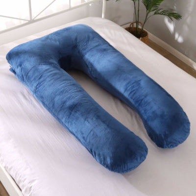 Coussin de grossesse CalinForm™ en velours bleu foncé en forme U, posé sur un lit blanc, idéal pour soulager le dos et le ventre pendant la grossesse.