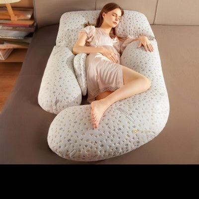 Femme enceinte reposant sur un coussin de grossesse Coolmax beige à motifs géométriques, offrant un confort optimal sans accessoires visibles.