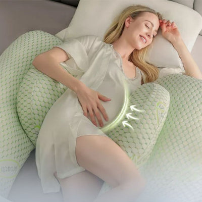 Femme enceinte allongée sur un coussin de grossesse en forme de U, offrant un soutien optimal au ventre et au dos pour un sommeil confortable.