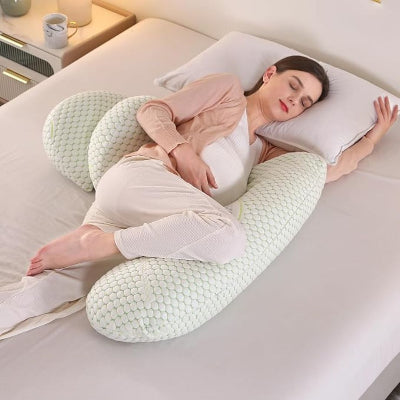 Femme enceinte dormant sur le côté avec un coussin de grossesse bras long, offrant un soutien ergonomique pour le ventre et les jambes.