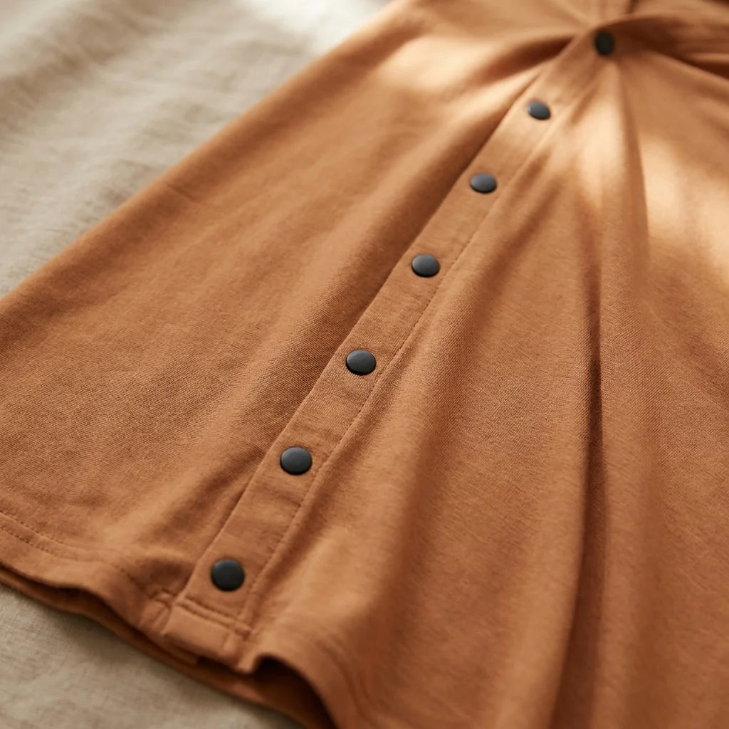 Gros plan détail rangée de boutons-pression du DouceEnvol™ caramel — finition soignée, réglage précis