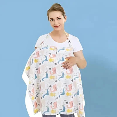 Cape d’allaitement colorée à motifs dinosaures portée par une maman souriante, assurant intimité et confort pendant l’allaitement, fond bleu uni.

