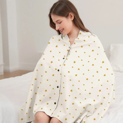 Écharpe d'allaitement DouxVoile blanc cassé étoiles dorées portée en couverture sur lit — boutons pression noirs, coupe enveloppante