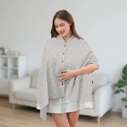 Écharpe d'allaitement DouxVoile gris perle étoiles blanches portée en châle dans salon moderne — coupe ample, main sur ventre, lumière douce