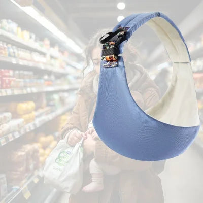 Maman avec bébé en écharpe de portage bébé bleu clair dans un supermarché – portage physiologique en sortie.