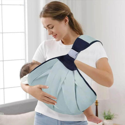 Maman portant son bébé dans une écharpe de portage vert menthe en position d’allaitement, contact peau à peau rassurant.