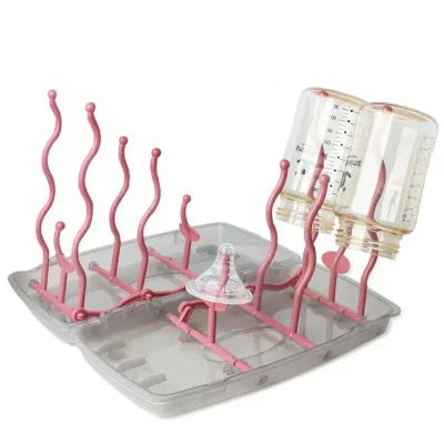 Égouttoir biberon pliable avec tiges roses accueillant biberons et tétines, conçu pour sécher jusqu’à 12 accessoires sans contact avec l’eau.