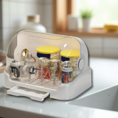 Égouttoir biberon dans une cuisine lumineuse, contenant des pots, des biberons et des tasses d’apprentissage, conçu pour un rangement bébé hygiénique et compact.