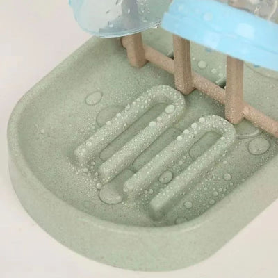 Zoom sur la base de l’égouttoir biberon montrant l’accumulation d’eau évacuée naturellement, garantissant une hygiène optimale.