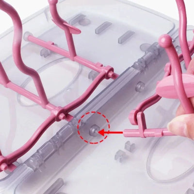 Détail du système de fixation de l’égouttoir biberon rose montrant un montage facile et démontable, idéal pour un nettoyage complet et une hygiène bébé optimale.