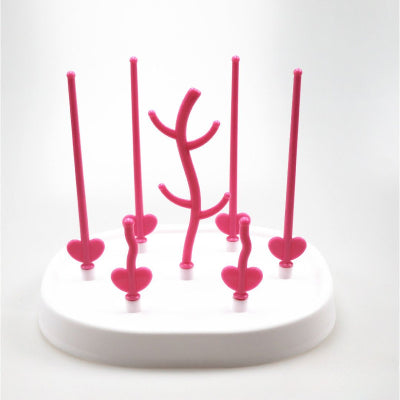 Egouttoir biberon rose framboise avec branches longues et courtes pour un support multifonction, séchage rapide et gain de place sur le plan de travail.