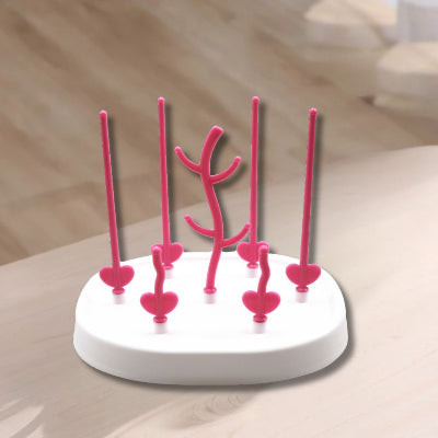 Egouttoir biberon rose utilisé sur une table de cuisine, illustrant son design gain de place et sa capacité à sécher plusieurs biberons et petits accessoires simultanément.