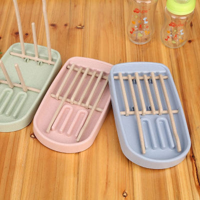  Ensemble des égouttoirs biberon en trois coloris pastel (rose, bleu, vert), parfaits pour organiser les accessoires de bébé avec style dans une cuisine moderne.