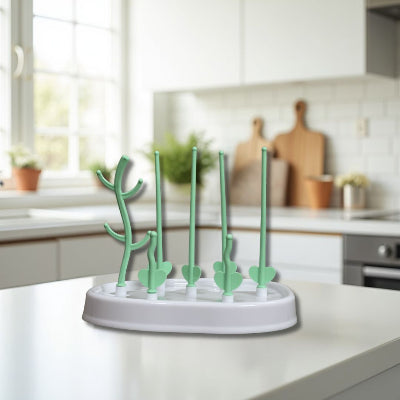 Egouttoir biberon vert pastel posé dans une cuisine familiale lumineuse, démontrant son intégration esthétique et pratique dans un environnement de jeunes parents.