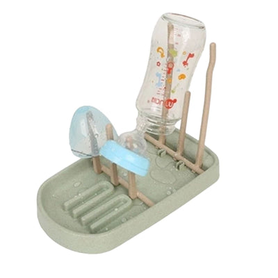Egouttoir biberon vert menthe en cours d’utilisation, accueillant biberon en verre, tétine et capuchon pour un séchage sain et sans stagnation d’eau.