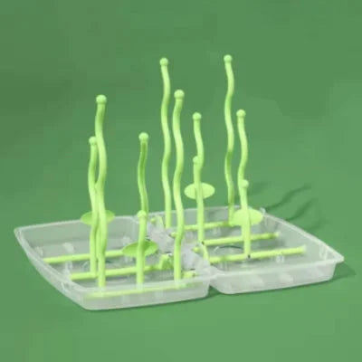  Égouttoir biberon pliable vert avec bras ondulés sur socle transparent, parfait pour les accessoires de puériculture lors de déplacements ou à la maison.