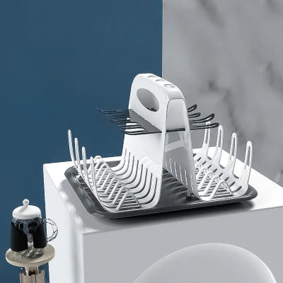 Égouttoir biberon vide dans un décor épuré, soulignant son design compact, sa structure stable et ses supports pour biberons, cuillères et tétines.