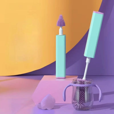 Goupillon biberon violet posé à côté d’un biberon à anses, dans un décor pastel apaisant, conçu pour les jeunes parents cherchant hygiène et rapidité.

