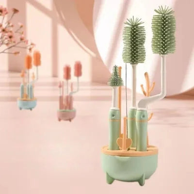 Kit de goupillon biberon complet vert tendre avec base de rangement en forme d’arbre, contenant brosses tétines, pailles et biberons, présenté en intérieur lumineux.
