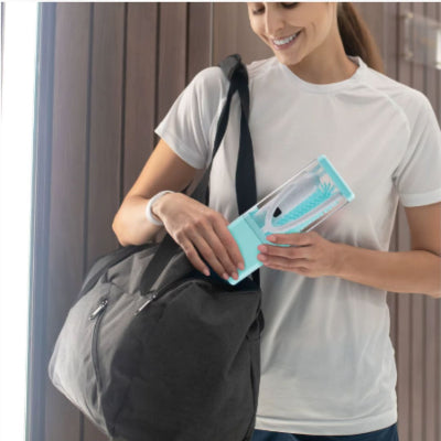 Maman rangeant le goupillon biberon compact et portable dans un sac de sport, idéal pour les déplacements.