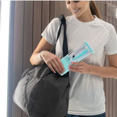 Maman rangeant le goupillon biberon compact et portable dans un sac de sport, idéal pour les déplacements.