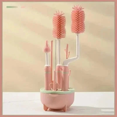 Goupillon biberon coloris rose pêche avec support en forme d’arbre, conçu pour un séchage vertical et une organisation optimale des accessoires bébé.