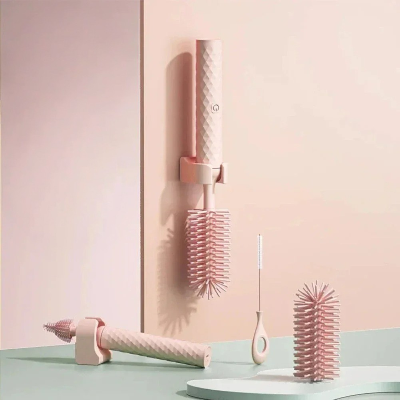 Goupillon biberon électrique rose pastel avec support mural, embouts interchangeables et mini brosse pour pailles, idéal pour un nettoyage bébé complet et hygiénique.