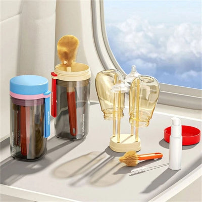 Utilisation du goupillon pour biberon en situation de voyage, avec brosses et égouttoir en action à côté de biberons séchant en avion, démontrant son utilité lors de sorties familiales.