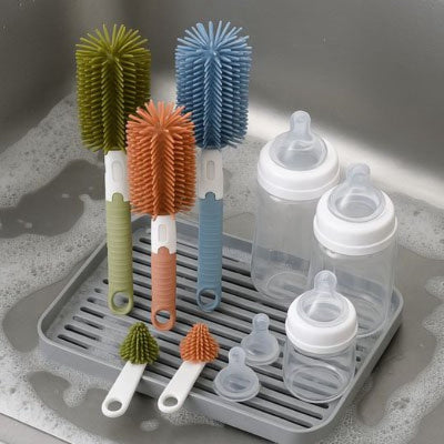 Kit nettoyage biberon avec goupillons en silicone de différentes couleurs, utilisé pour nettoyer biberons et tétines dans l’évier.