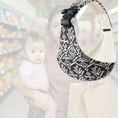 Jeune maman portant son bébé au supermarché sans écharpe de portage, visiblement fatiguée, tenant des sacs en main.
