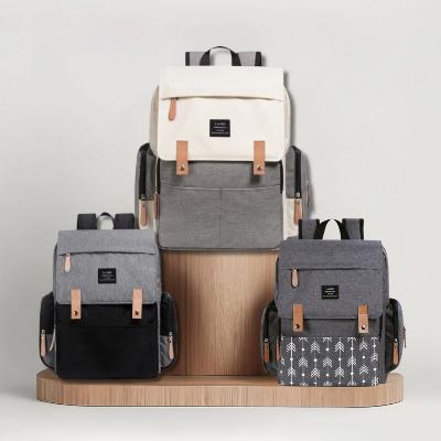 Sac à Dos à Langer ÉlégancePlus™ - Charbon Chic, Écru Élégance et Gris Nordic présenté ensemble. Découvrez ces trois variantes élégantes pour un style adapté à chaque parent.