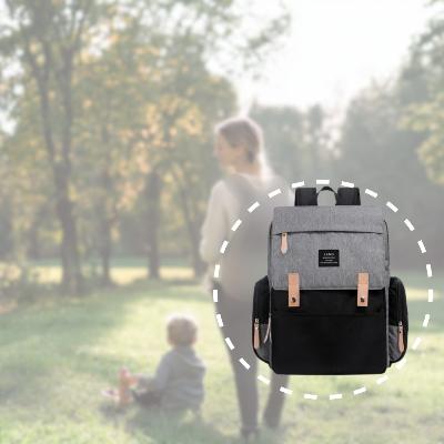 Le Sac à Dos à Langer ÉlégancePlus™ mis en scène lors d'une promenade au parc, idéal pour organiser les essentiels de bébé en déplacement.