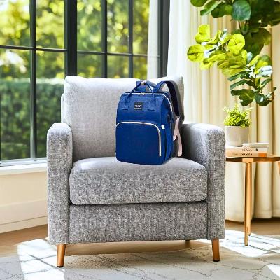 Sac à langer Nomade PeacePod bleu, élégant et pratique, posé sur un fauteuil pour illustrer son style moderne et raffiné.