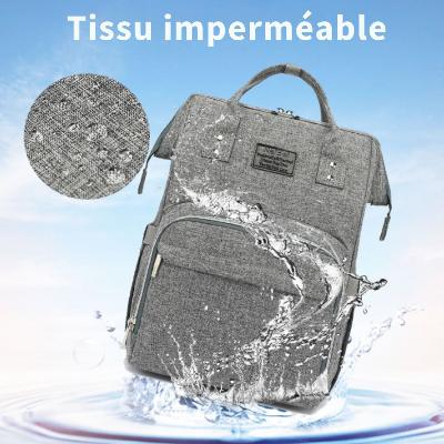 Le sac à langer SerenityPack™ sur une surface blanche, mettant en évidence son tissu imperméable grâce à des gouttelettes d'eau.