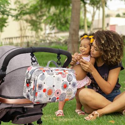 Sac à langer bébé HappyNest™ attaché à la poussette, avec design à cercles colorés, idéal pour des moments complices avec votre enfant.