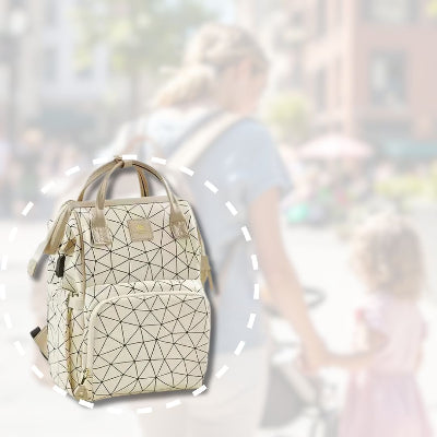 Sac à dos à langer champagne lumière avec poches pratiques, porté par une maman tenant la main de sa fille, idéal pour les sorties quotidiennes.