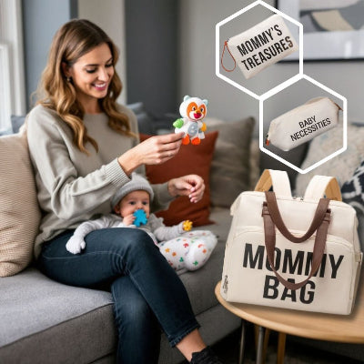 Une maman joue avec son bébé dans un salon moderne avec un sac à langer crème élégance posé sur une table, accompagné de 2 pochettes pratiques.