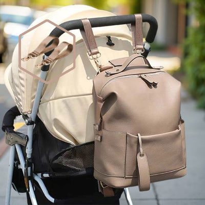 Gros plan sur un sac à langer moka avec ses sangles ajustables attachées à une poussette, parfait pour une organisation optimale en déplacement.