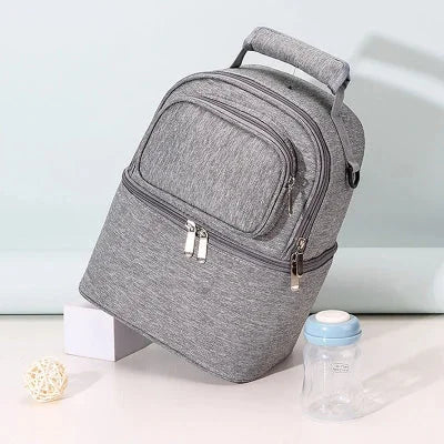 Sac isotherme Bebe gris BibiCool™ avec bouteille, illustrant l’usage quotidien pour transporter lait ou collation.