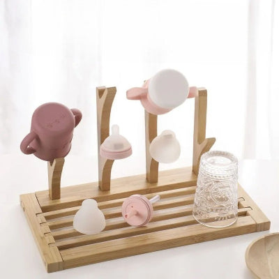 Sèche biberon en bambou DryNest™ utilisé avec tétines, tasses d’apprentissage et verres, polyvalent pour tous les accessoires repas de bébé et du quotidien.