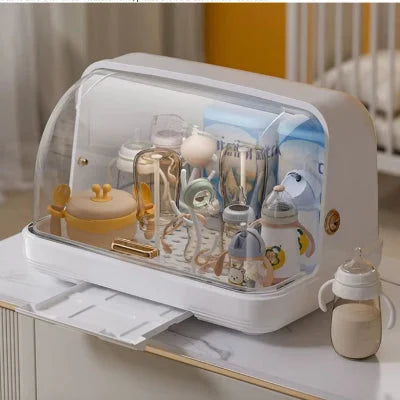 Sèche biberon BibStand™ avec bac récupérateur d’eau en position ouverte, installation sur plan de travail dans une chambre de bébé moderne.

