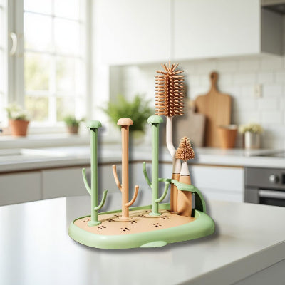 Sèche biberon CleanDrop™ dans une cuisine lumineuse avec fenêtre, en version vert et beige, idéal pour le rangement biberon et accessoires d’allaitement.

