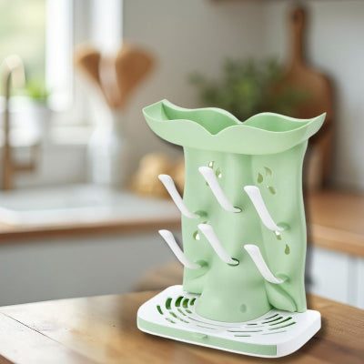  Sèche biberon en cours d’utilisation avec plusieurs biberons en verre et plastique, séchant efficacement sur crochets inclinés dans une cuisine moderne.