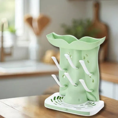  Sèche biberon en cours d’utilisation avec plusieurs biberons en verre et plastique, séchant efficacement sur crochets inclinés dans une cuisine moderne.