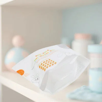 Stérilisateur biberon sous forme de sac micro-ondes réutilisable, présenté dans une chambre de bébé aux tons pastel, idéal pour désinfecter rapidement les accessoires de puériculture.

