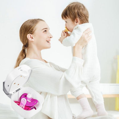 Maman souriante tenant son bébé tout en lui donnant une tétine propre, stérilisée avec LumiTétine visible au premier plan.