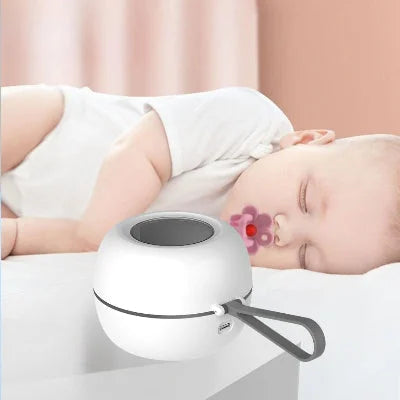 Stérilisateur tétine posé sur une table de nuit à côté d’un bébé endormi avec tétine, illustrant l’usage nocturne silencieux et sécuritaire pour une hygiène continue même la nuit.

